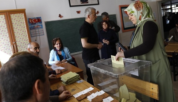 A woman casts her ballot at a polling station during a referendum in Ankara