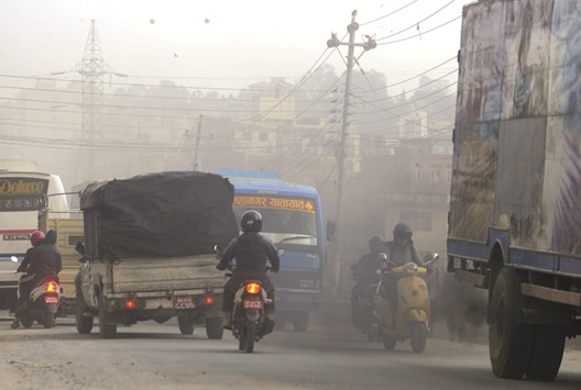 Motorbike riders travel on a polluted road in Kathmandu yesterday.