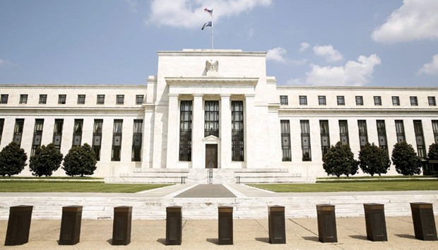 The Federal Reserve building is seen in Washington. A further cooling of price pressures and modest household demand would raise questions about whether the economy could withstand a mid-year move by the Fed to lift borrowing costs.