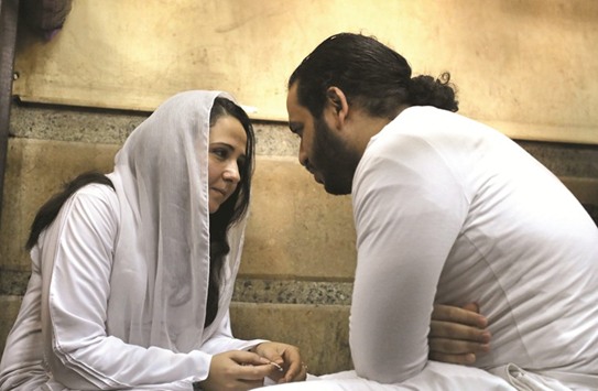 File photo shows Aya Hijazi and her husband Mohamed Hassanein, founders of Belady, an NGO that promotes a better life for street children, sitting on the ground talking inside a holding cell as they face trial on charges of human trafficking at a courthouse in Cairo, Egypt.