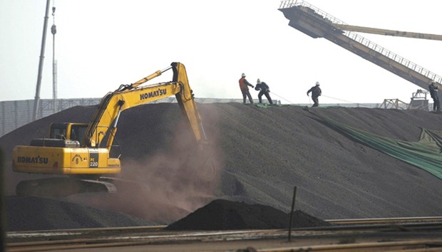 Labourers work on a pile of iron ore at a steel factory in China. Iron ore entered a bear market last week as a procession of analysts, Australiau2019s government and even some miners said gains to the highest since 2014 were unsustainable.