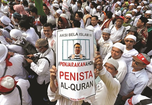 A December 2016 file photo of an Indonesian holding up a poster during a rally calling for the arrest of Jakartau2019s Governor Basuki Tjahaja Purnama.