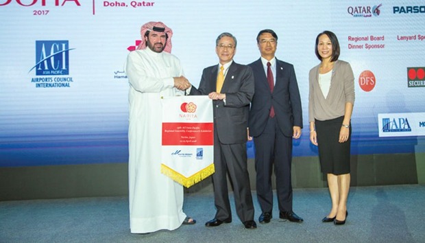 Abdulaziz al-Mass handing over the flag to Kenichi Fukaya in the presence of Futoshi Osada, executive vice-president, Narita International Airport and Patti Chau.