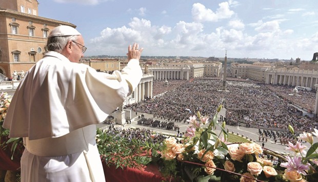 Pope Francis waves while delivering his u2018Urbi et Orbiu2019 (to the city and the world) message from the balcony overlooking Saint Peteru2019s Square at the Vatican.