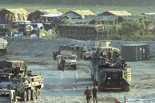 File photo shows US marines walking next to their transport and amphibious vehicles at a temporary camp for the u201cBalikatanu201d joint US-Philippine military exercise at Crow Valley, in Capas town, north of Manila.