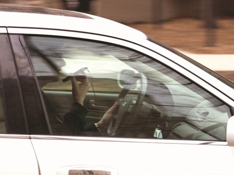 A driver uses a cellphone while behind the wheel in Evanston.