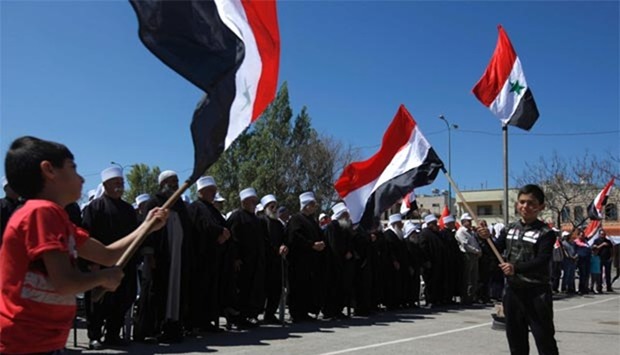 Druze residents of the Masada village in the Israeli-occupied Golan Heights hold Syrian national flags during a rally marking Syria's Independence Day on Monday.