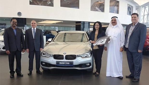 Beena George after receiving the key to the BMW 318i from al-Darwish and Allam. PICTURE: Joey Aguilar
