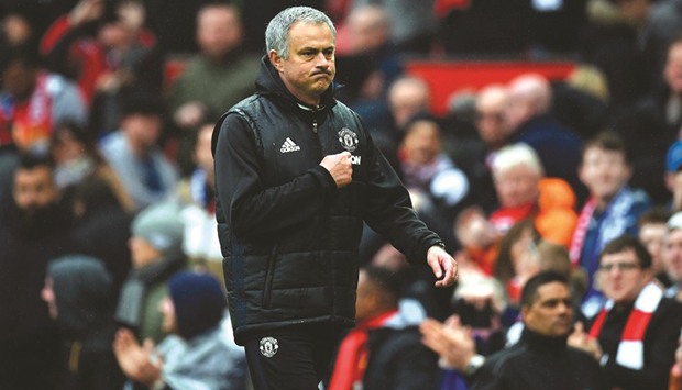Manchester Unitedu2019s Portuguese manager Jose Mourinho points at the badge on his chest as he leaves the pitch at the end of the EPL match against Chelsea at Old Trafford.