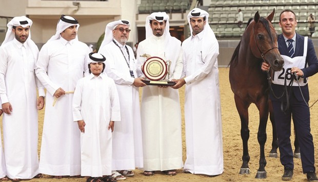 Owner Nasser Mohamed Mesfer al-Hajri receives the trophy after Gazwan Al Nasser was adjudged as the Champion Stallion in the 5th Qatar National Arabian Horse Show for Individual Owners at Al Shaqabu2019s Indoor Arena on Sunday. PICTURES: Juhaim