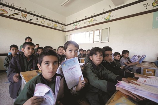 Students listen to a teacher in class at a school in Sanaa, yesterday.