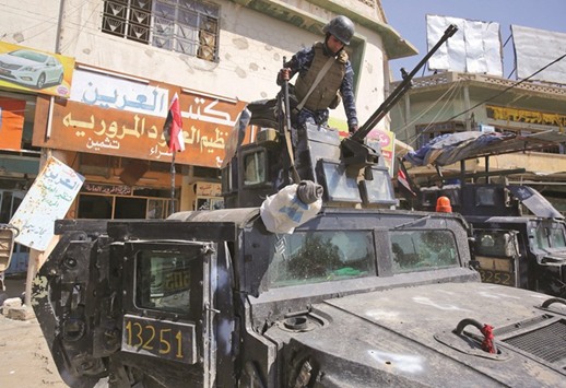 A member of the Iraqi forces sits in a turret over a humvee in the Old City of Mosul yesterday.