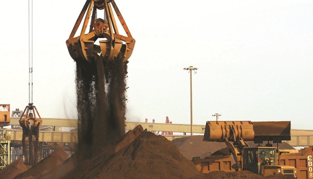 Cranes unload imported iron ore from a ship at a port in China. The raw material for steel-making entered a bear market this month as a procession of analysts, Australiau2019s government and even some miners said gains to 2014 highs were unsustainable amid rising supply.
