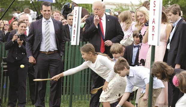 President Trump and his son Donald Trump Jr watch children roll Easter Eggs at 139th annual White House Easter Egg Roll on the South Lawn of the White House.