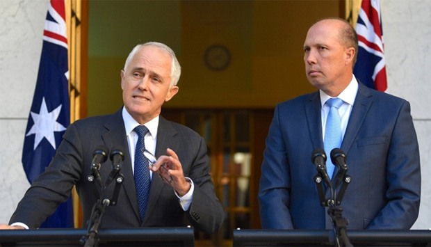 Australia's Prime Minister Malcolm Turnbull speaks as Immigration Minister Peter Dutton listens