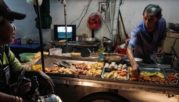 A street food vendor talking to a customer in the Phrakanong district of Bangkok