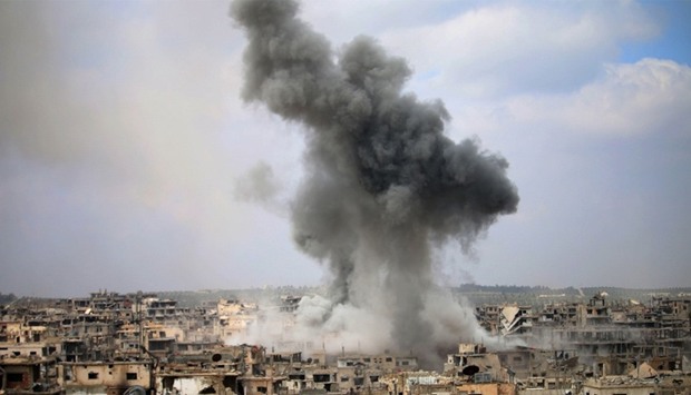 Smoke billows following a reported air strike on a rebel-held area in the southern Syrian city