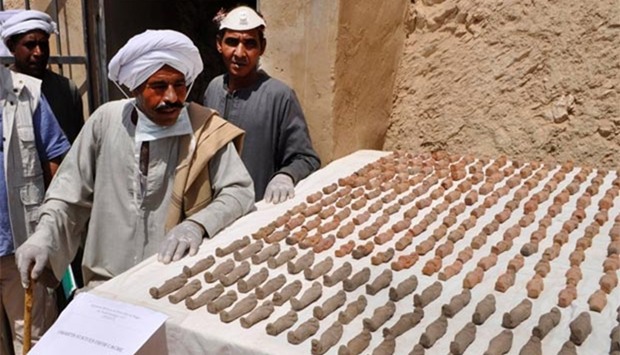 Members of an Egyptian archaeological team stand near artefacts discovered in a 3,500-year-old tomb in the Draa Abul Nagaa necropolis, near Luxor, on Tuesday.