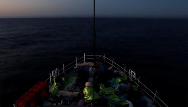 Migrants rest on a ship after being rescued in the central Mediterranean off the Libyan coast.