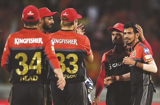 Royal Challengers Bangaloreu2019s Yuzvendra Chahal (R) is congratulated by teammates after the dismissal of Gujarat Lions captain Suresh Raina during their IPL match at the Saurashtra Cricket Association Stadium in Rajkot yesterday. (AFP)