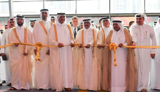 HE the Minister of Transport and Communications Jassim Seif Ahmed al-Sulaiti cuts a ribbon to open Qatar Motor Show 2017 on Tuesday as HE the Minister of Municipality and Environment Mohamed bin Abdullah al-Rumaihi and other dignitaries look on. PICTURE: Noushad Thekkayil.