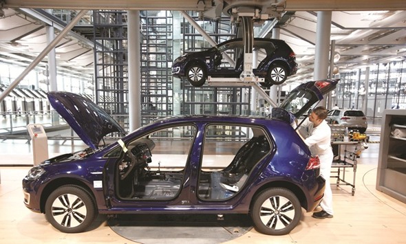 A worker assembles an e-Golf electric car at the production line of the Transparent Factory of Volkswagen in Dresden, Germany. VW aims to launch 10 electric vehicles between 2020 and 2025.