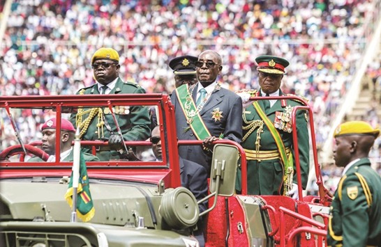 Zimbabweu2019s President Robert Mugabe reviews the guard of honour during the countryu2019s 37th Independence Day celebrations at the National Sports Stadium in Harare.