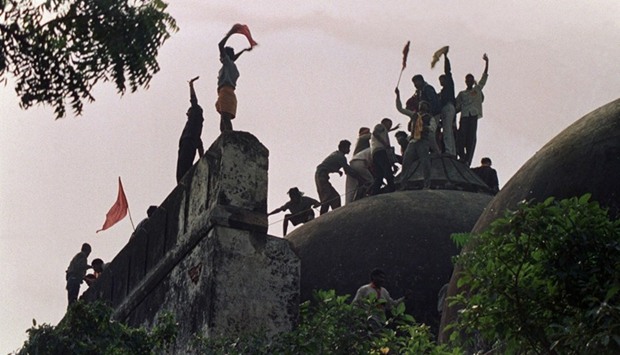 Hindu fundamentalists shouting and waving banners as they stand on top of a stone wall and celebrate the destruction of the 16th century Babri Mosque in Ayodhya. File photo, December 6, 1992.