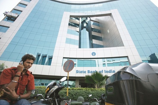 A man speaks on a mobile phone outside the State Bank of India building in Mumbai. SBIu2019s perpetual notes are being hoarded and hunted by traders betting the nationu2019s  biggest lender will buy them back within the next 10 weeks as it puts its capital structure in line with Basel regulations.