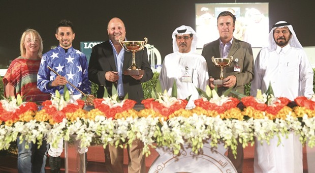 Qatar Racing and Equestrian Club (QREC) vice chief steward Abdulla Rashid al-Kubaisi (third from right) with the winners of Al Zubara Cup, after Aaley Al Magam won the 1900m feature at the QREC yesterday. PICTURE: Juhaim