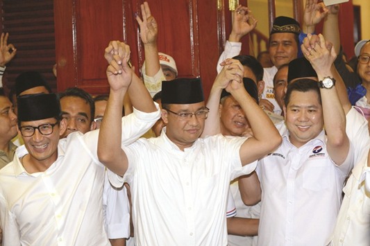 Jakarta governor-elect Anis Baswedan (centre), his deputy governor-elect Sandiaga Una (left) and Hary Tanoe of the Perindo party hold hands together during a press conference in Jakarta yesterday.