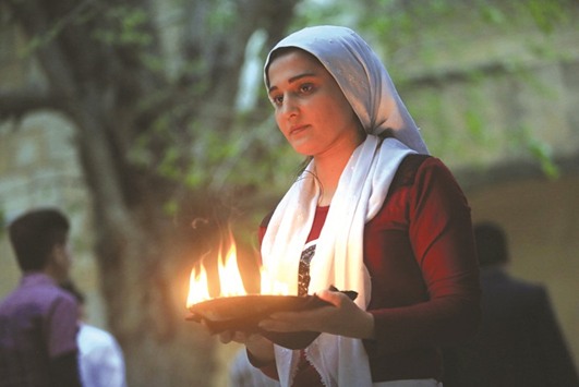 A woman from the minority Yazidi lights paraffin torches during a ceremony to celebrate the Yazidi New Year at Lalish temple in Shikhan in Dohuk province.