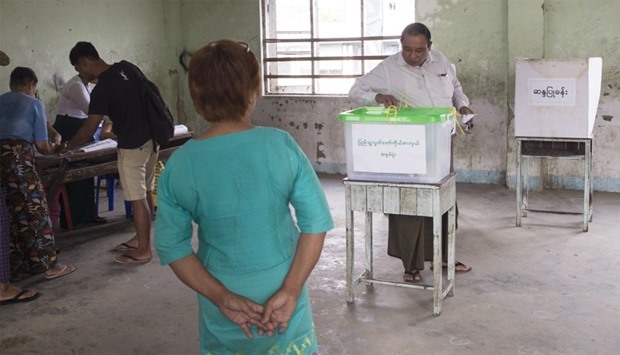 A man casts his vote in a by-election in a polling station in Dagon Seikkan township,  Yangon
