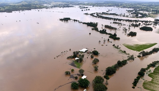Farmland and buildings can be seen surrounded by floodwaters