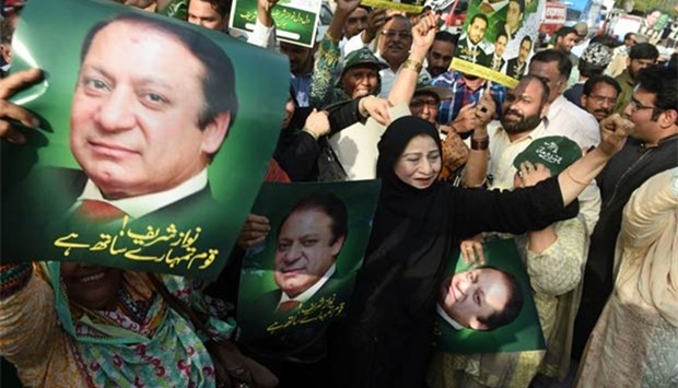 Supporters of the Pakistan Muslim League-Nawaz carry posters of Prime Minister Nawaz Sharif as they celebrate a Supreme Court verdict on the Panama Papers in Lahore on Thursday.