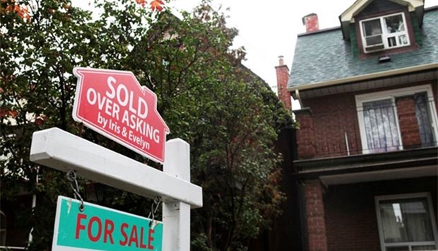 A ,Sold over asking, sign is on display on a house for sale in Toronto.