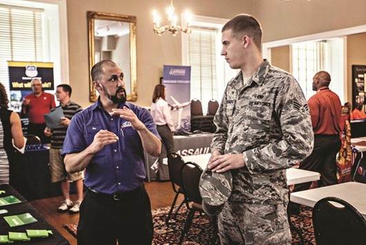 A job seeker (right), speaks with a representative with Cintas Corp during the Veterans Career Fair at the MacArthur Museum in Little Rock, Arkansas. Initial claims for state unemployment benefits in the US increased 10,000 to a seasonally adjusted 244,000 for the week ended April 15, the Labor Department said yesterday.