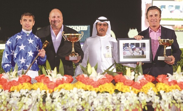 Qatar Racing and Equestrian Club (QREC) vice chief steward Abdulla Rashid al-Kubaisi with the winners of the Al Huwaila Cup after Najda won the 1850m race at the QREC yesterday. PICTURE: Juhaim