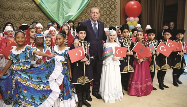 Erdogan poses yesterday with visiting children at the Presidential Palace in Ankara.
