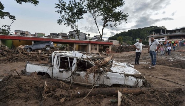 People look at the damages caused by mudslides following heavy rains in Mocoa, Colombia
