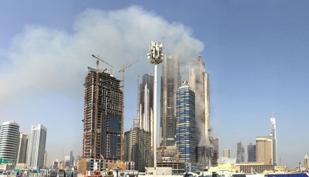 Smoke billows near the Dubai Mall and Burj Khalifa,  after a fire hit the construction site i