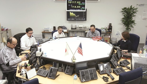 Currency traders work in the dealing room of a foreign exchange brokerage in Tokyo. The yen is advancing towards 105 per dollar, a level last seen just after US voters unexpectedly elected Trump in November.