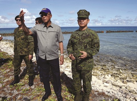 Defence Secretary Delfin Lorenzana (third left) gestures as he and military chief Eduardo Ano (right) inspect the runway of the airport during a visit to Thitu island in The Spratlys.