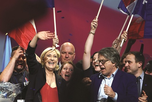 French presidential election candidate for the far-right Front National (FN) party Marine Le Pen reacts as she is flanked by FN party member of parliament Gilbert Collard (right) at the end of a campaign meeting on April 19, in Marseille, southern France.