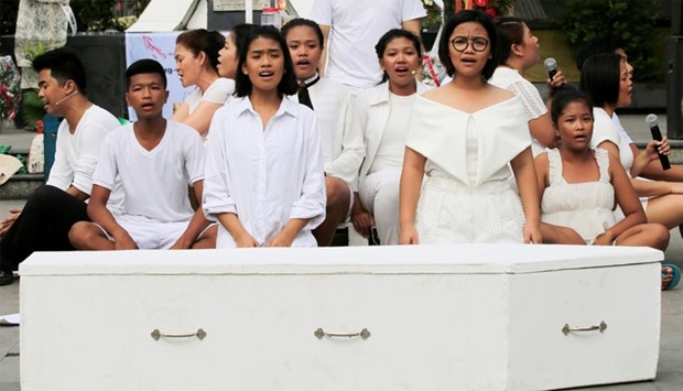 Filipino youth perform, in front of a mock coffin, a short musical about the anti-drug killings