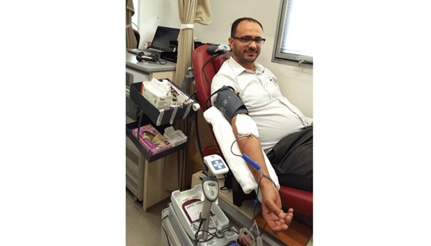 A staffer donating blood at QU Health Cluster.
