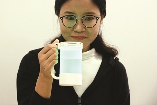 An NUS student tastes a virtual lemonade simulator, which uses electrodes to mimic the flavour and LED lights to imitate the colour of real lemonade, at the National University of Singapore campus.