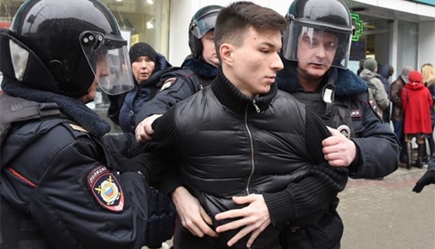 Russian police officers detain a man in central Moscow on Sunday.