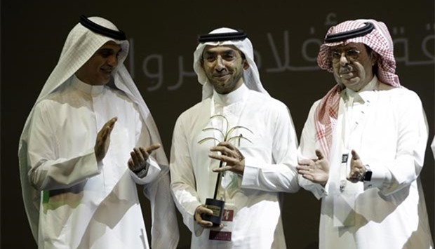 Saudi cameraman Ali Al-Sameen (centre) poses after receiving an award for his movie ,Couldn't kiss my face, during the closing ceremony of the 4th Saudi Film Festival.