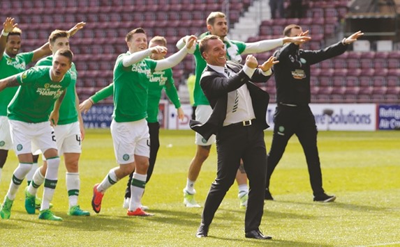 Celtic coach Brendan Rodgers and players celebrate after winning the Scottish Premiership title after thrashing Hearts 5-0 at Tynecastle, Scotland. (Reuters)